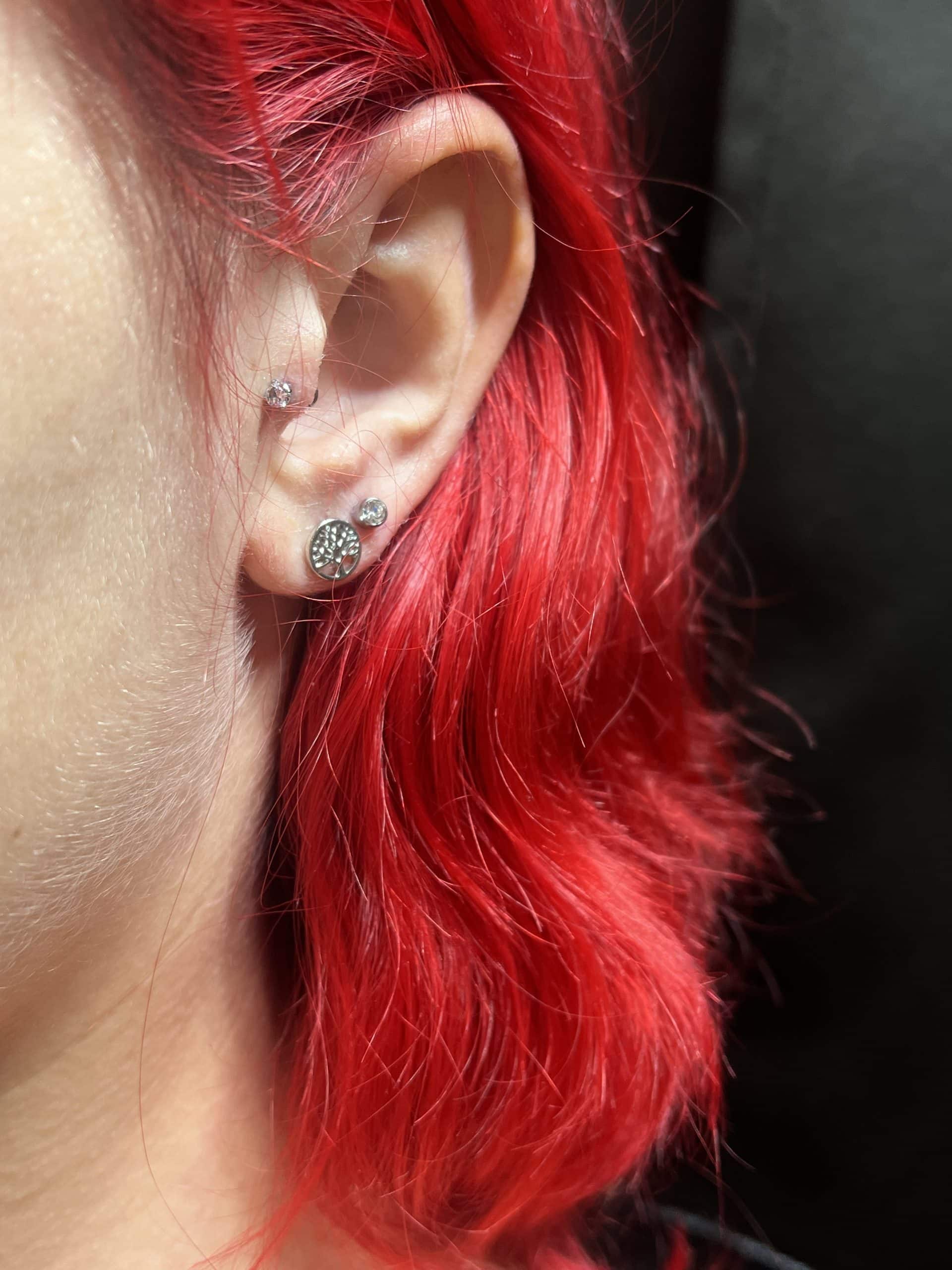 a close up of a woman with pink hair looking at the camera